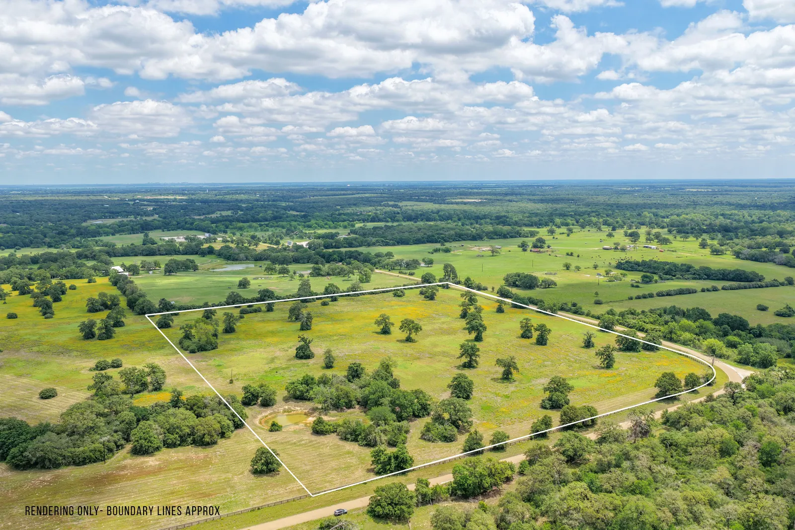 Country road running past open pasture on 26 acres along County Road 119 near Caldwell, Texas