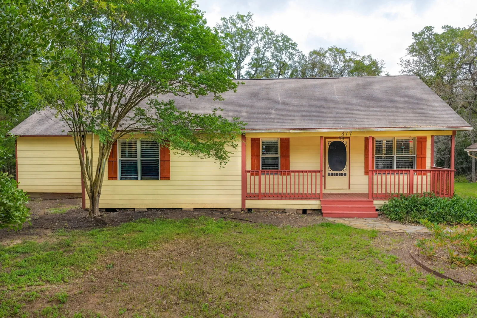 Single-story home with yellow siding and a covered front porch on Hollow Bend in Caldwell, Texas