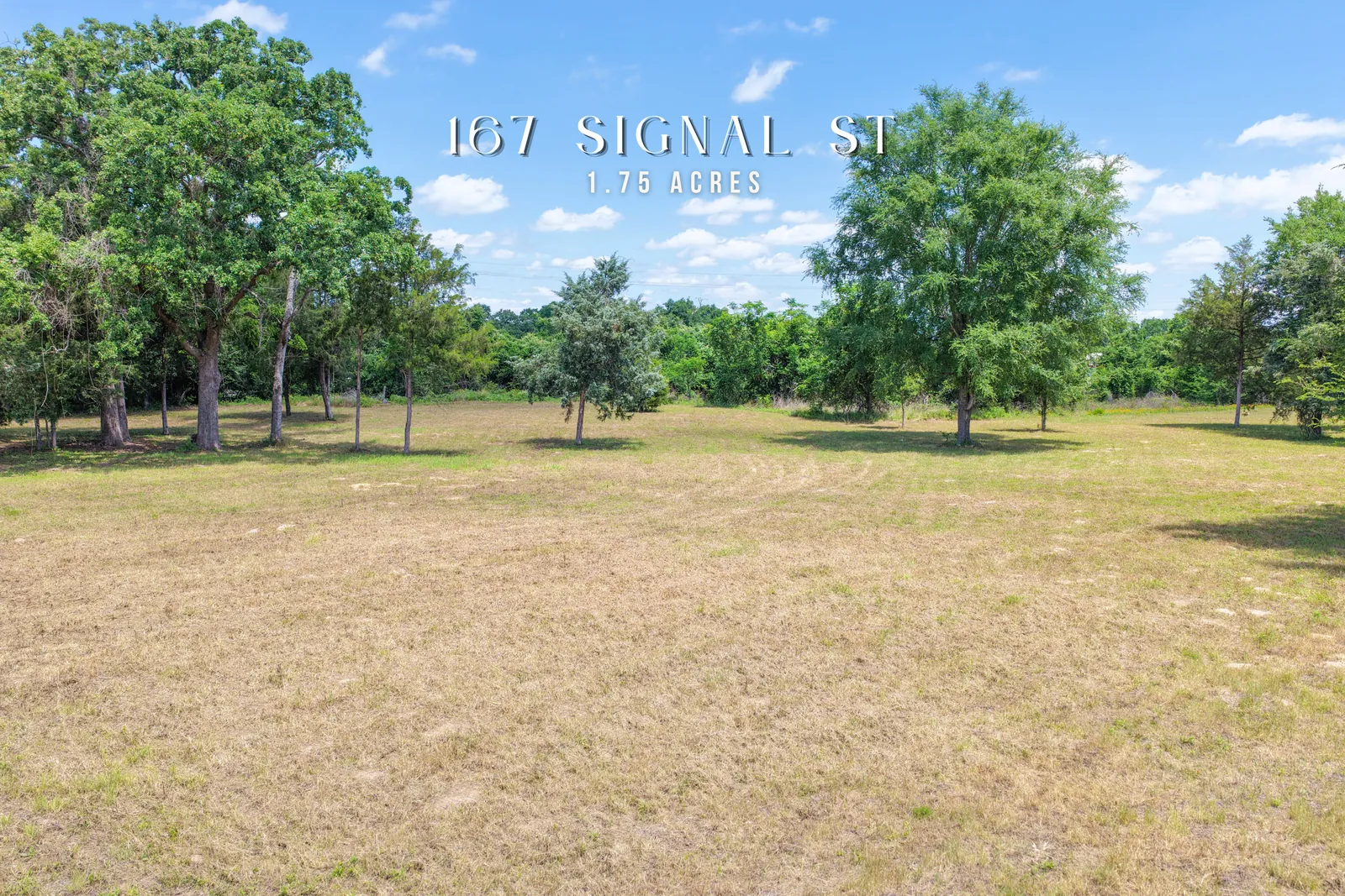 Grassy 1.75-acre lot dotted with mature trees on Signal Street near Somerville, Texas